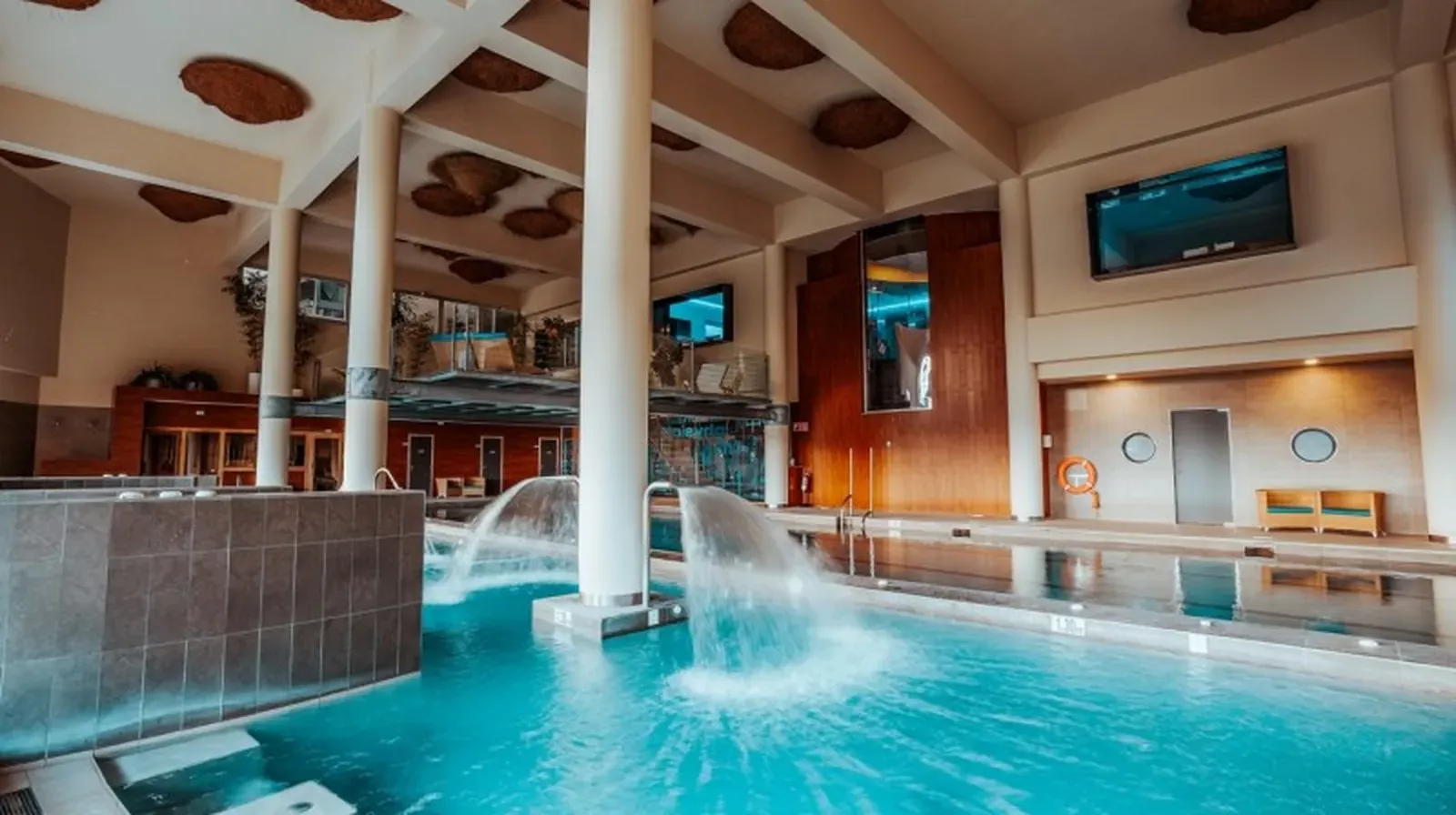 Indoor pool with waterfalls and warm lighting at the HW4 resort