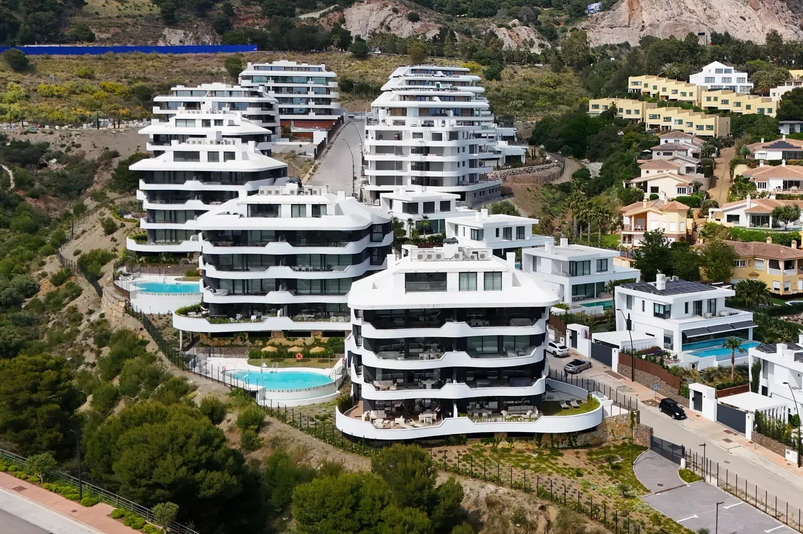 Aerial view of white apartment buildings and pools in Higuerón West