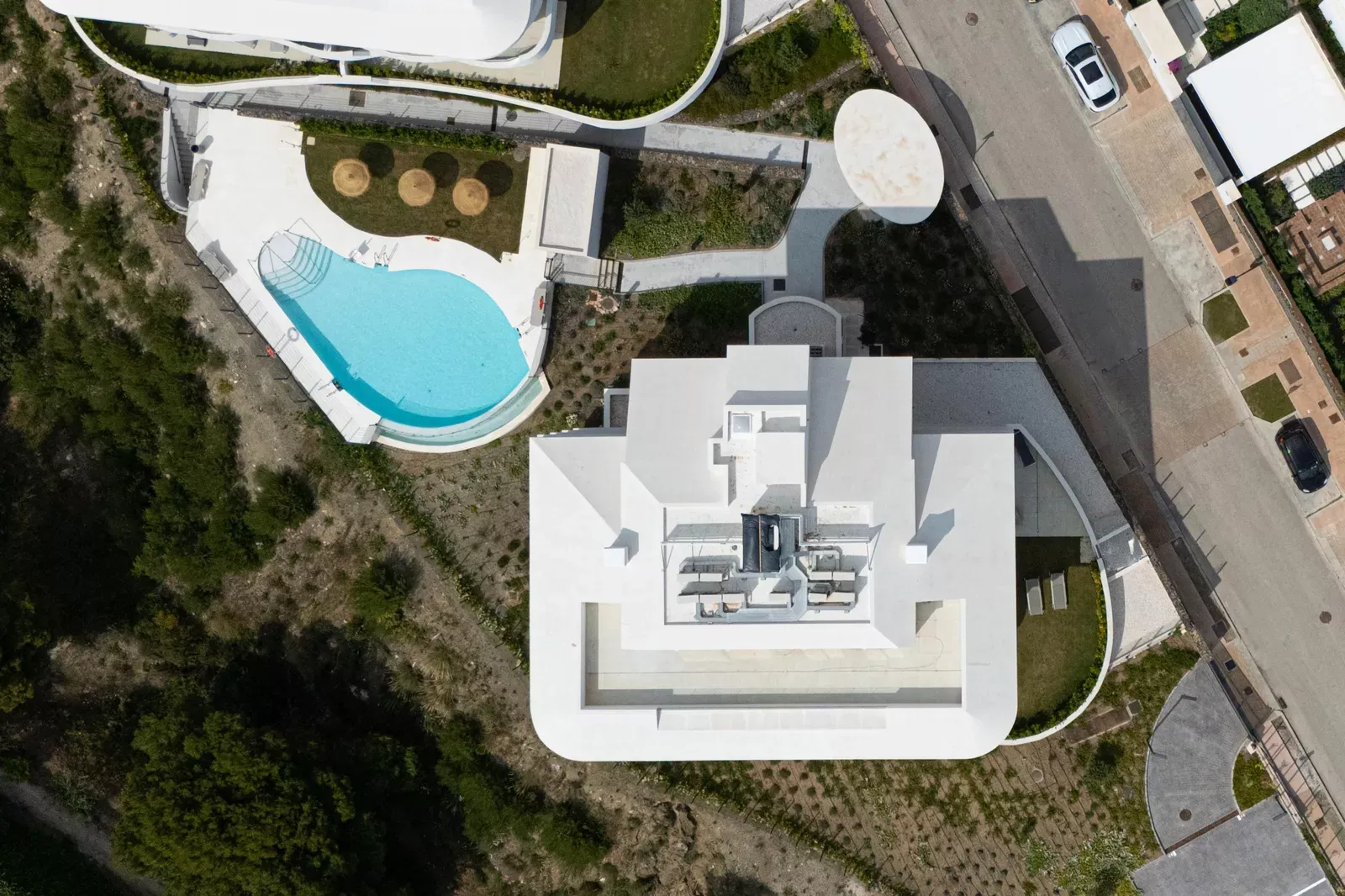 Aerial view of a pool and a white building at the HW3 development