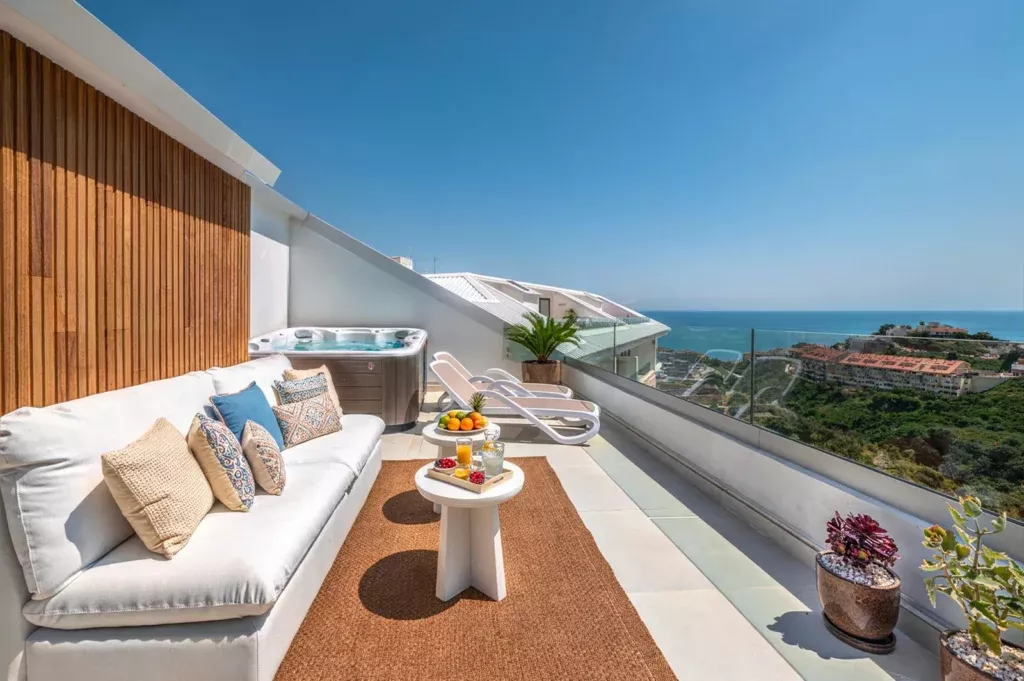 Terrace with sofas and a wooden wall facing the sea at Lomas Sky Villa