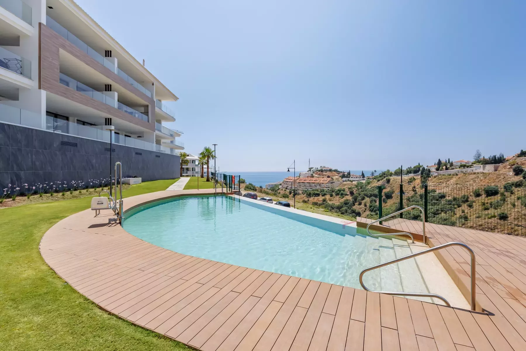 Communal pool with a wooden deck and lawn at Lomas 5, Higuerón
