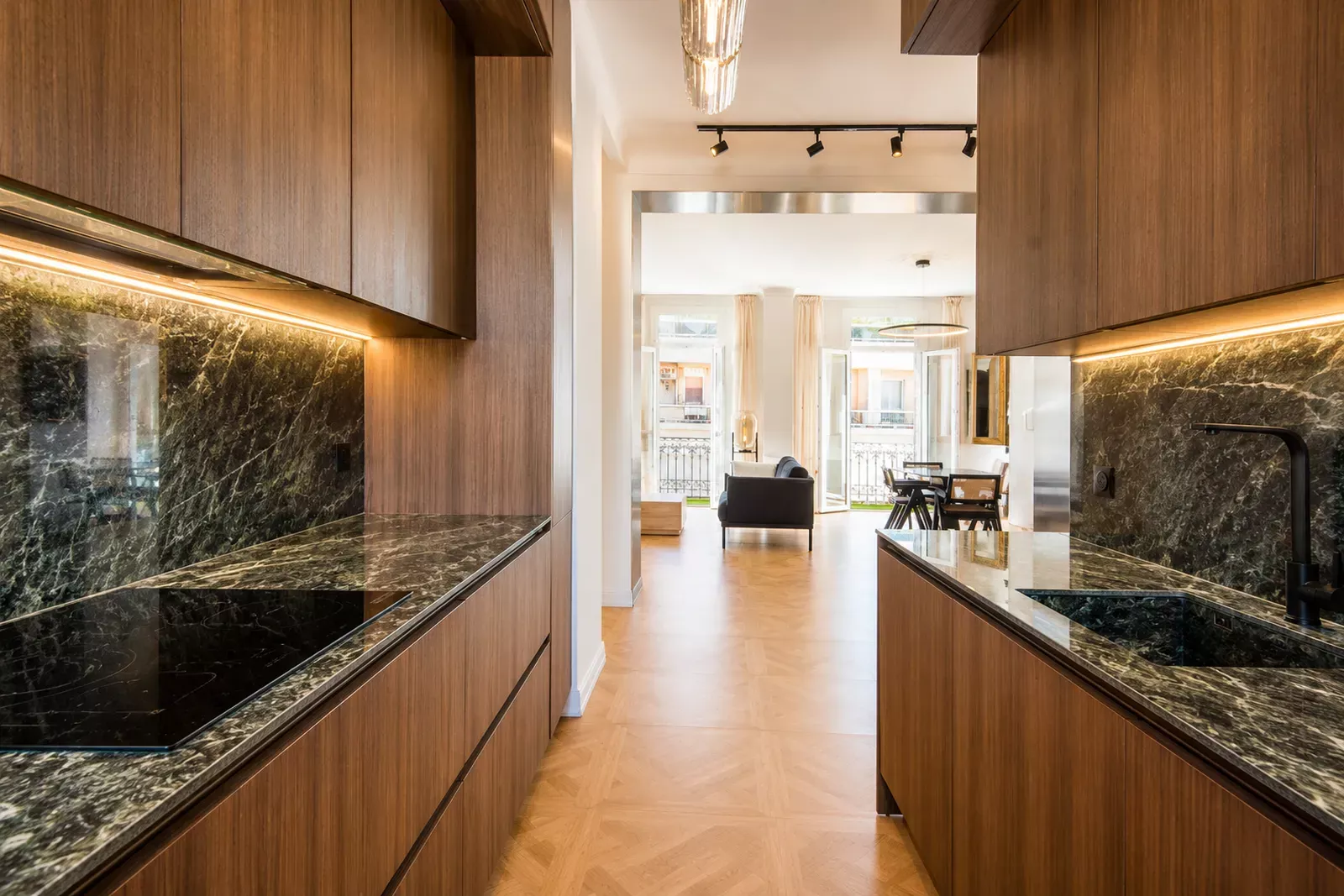 Kitchen with a dark stone worktop open to the living room in Nice