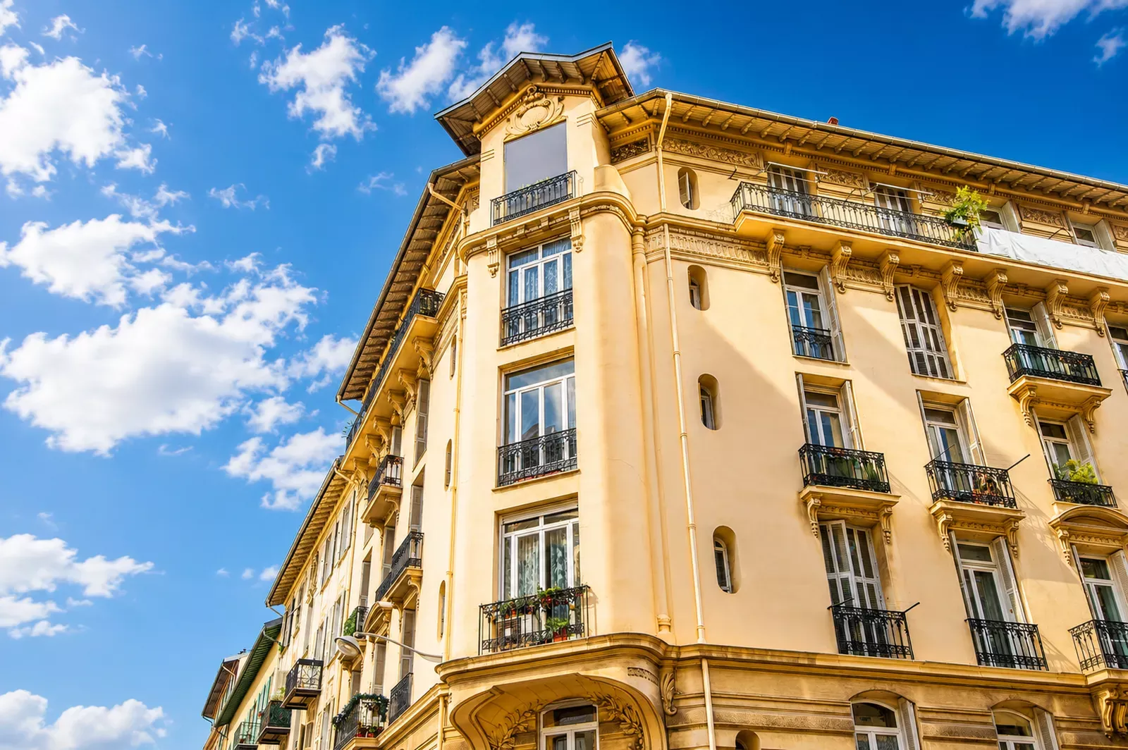 Belle Époque building façade with balconies against a blue sky in Nice