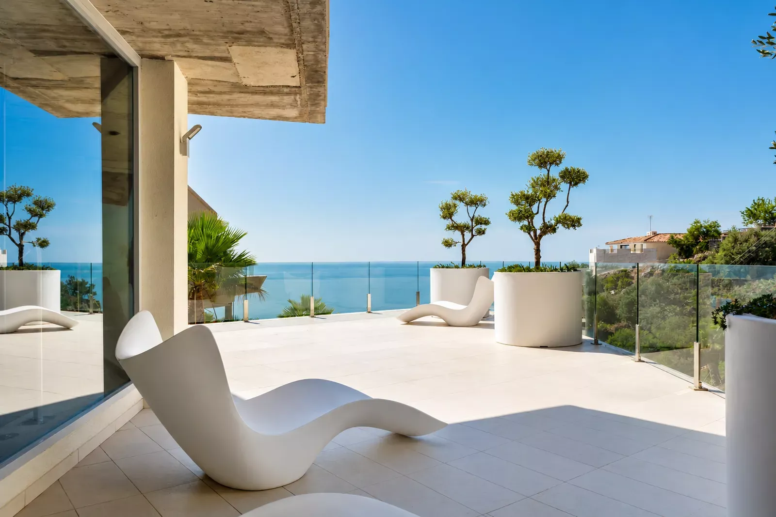 Stupa Hills terrace with sun loungers, plants and a view of the blue sea