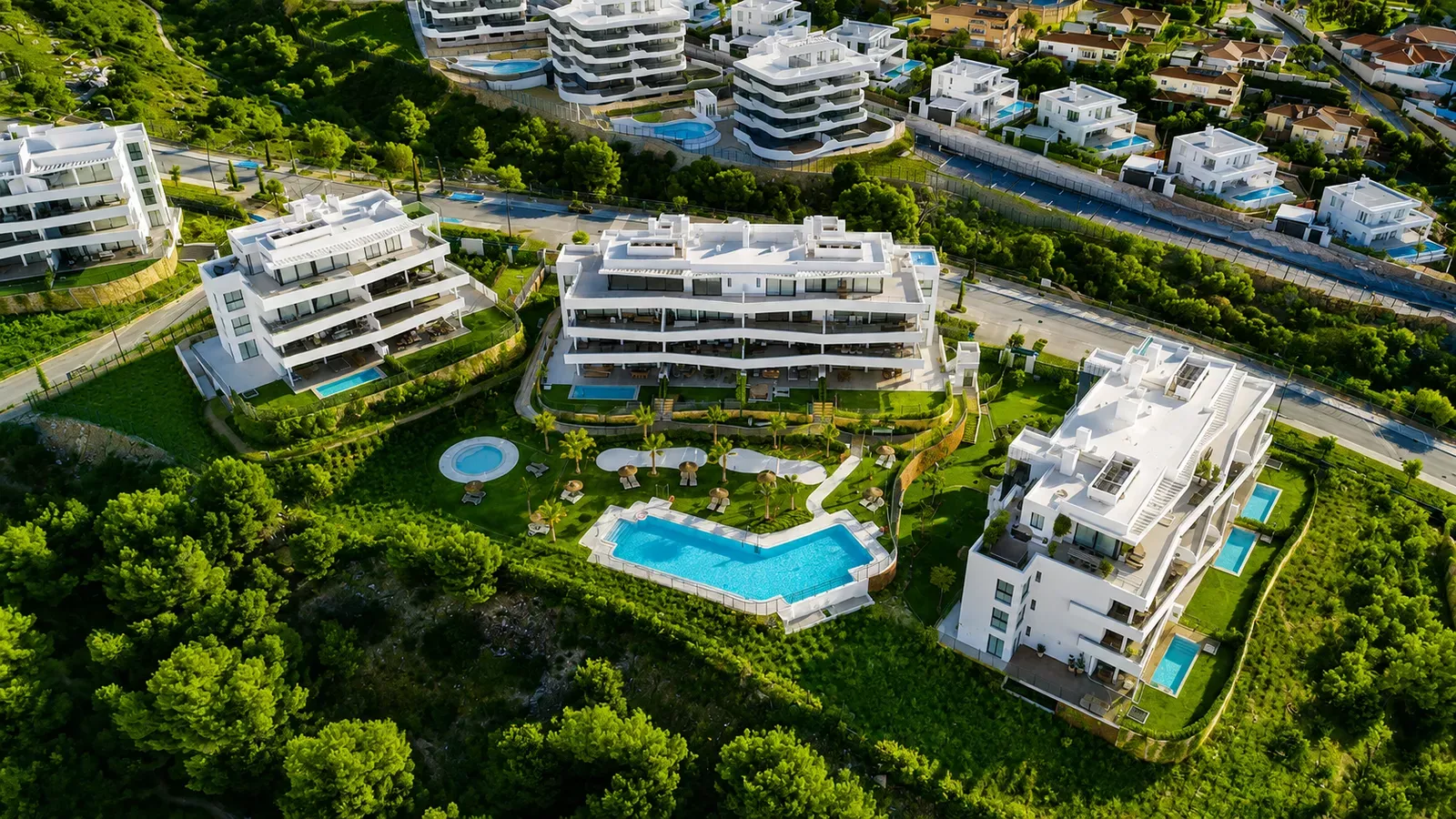 Birds-eye view of the Higuerón West complex with a pool and green lawns