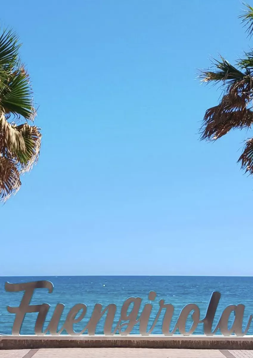 Palm trees and blue sea on a Fuengirola beach, cover of the Fuengirola area guide