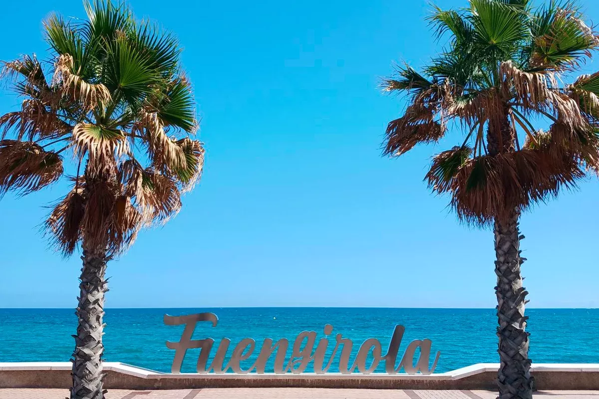 Palm trees and sea on the Fuengirola seafront with the town name written below
