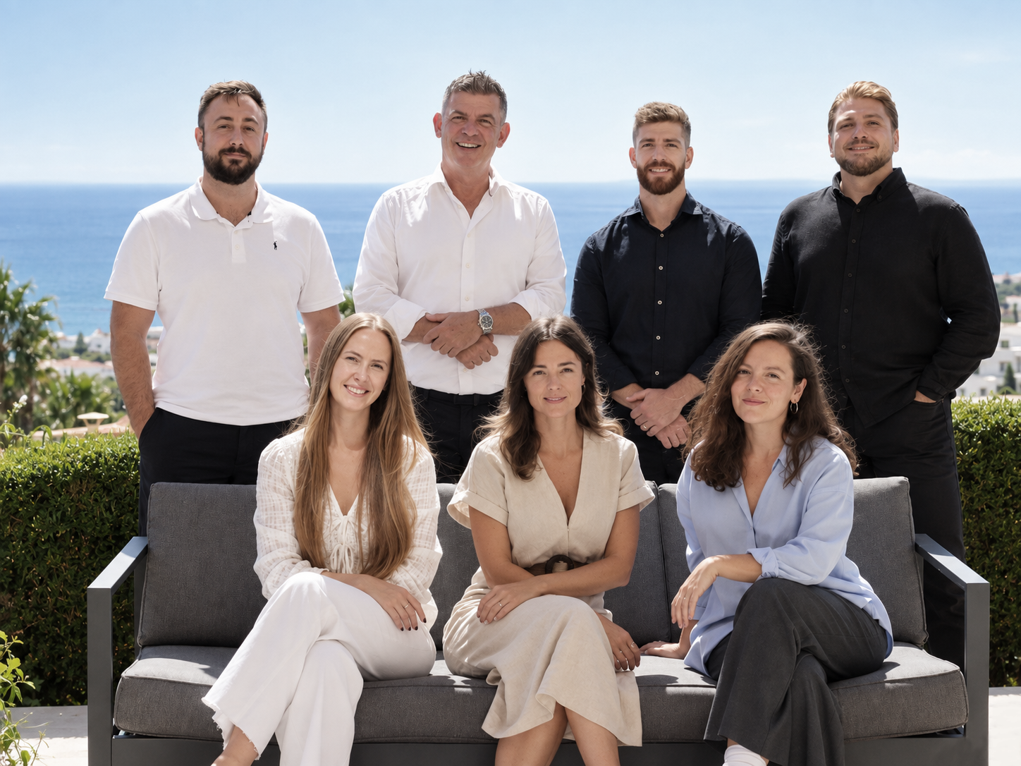 The five2one team posing together outdoors with the sea behind them