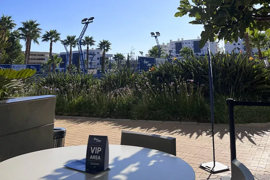 VIP area at the five2one padel tournament with tables, chairs and palm trees